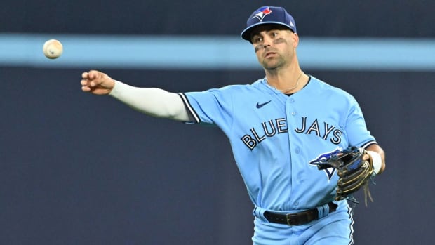 Blue Jays infielder Whit Merrifield throws a ball in a game.
